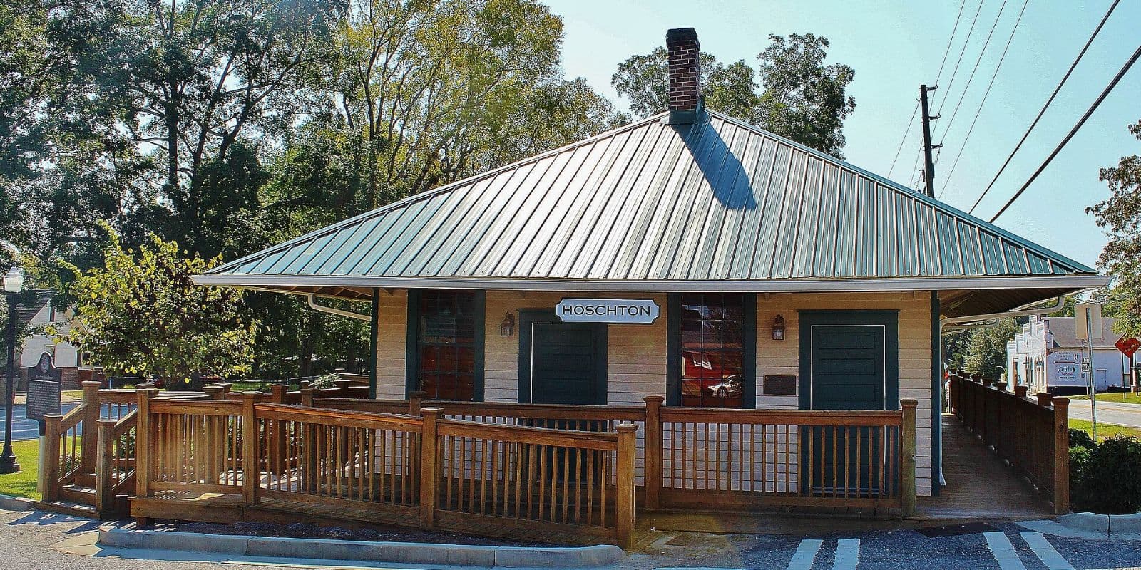 Historic Hoschton train depot with metal roof and wooden deck