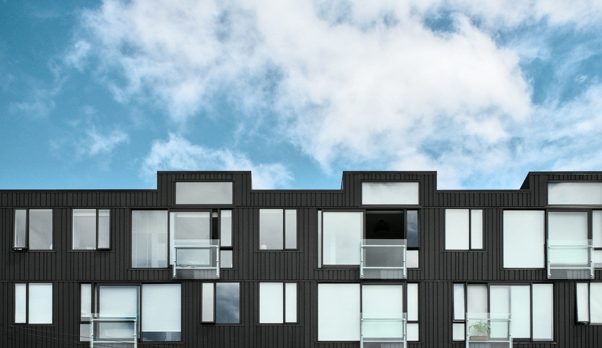 A modern apartment building against a blue sky