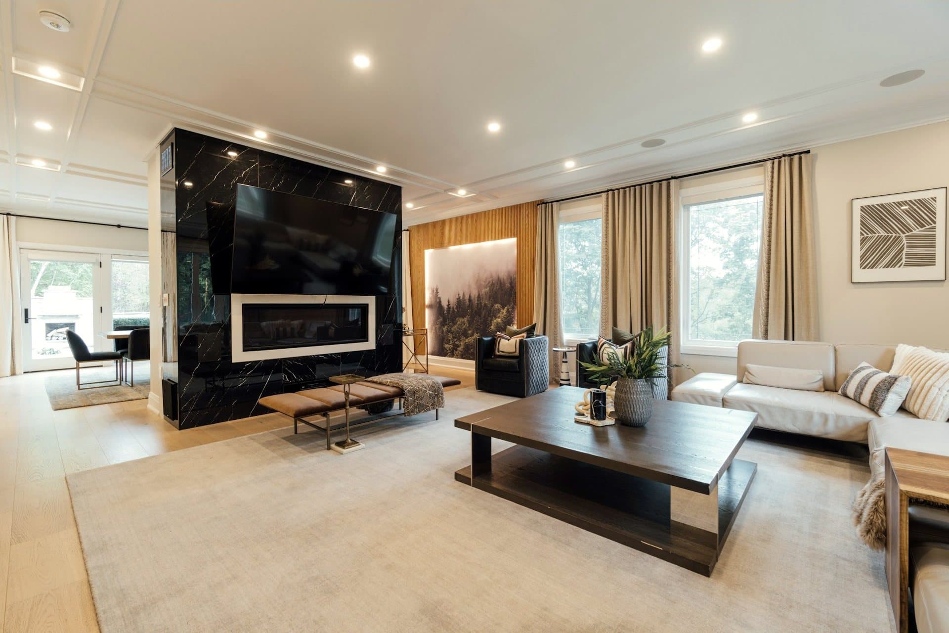 A living room anchored by a black marble fireplace wall